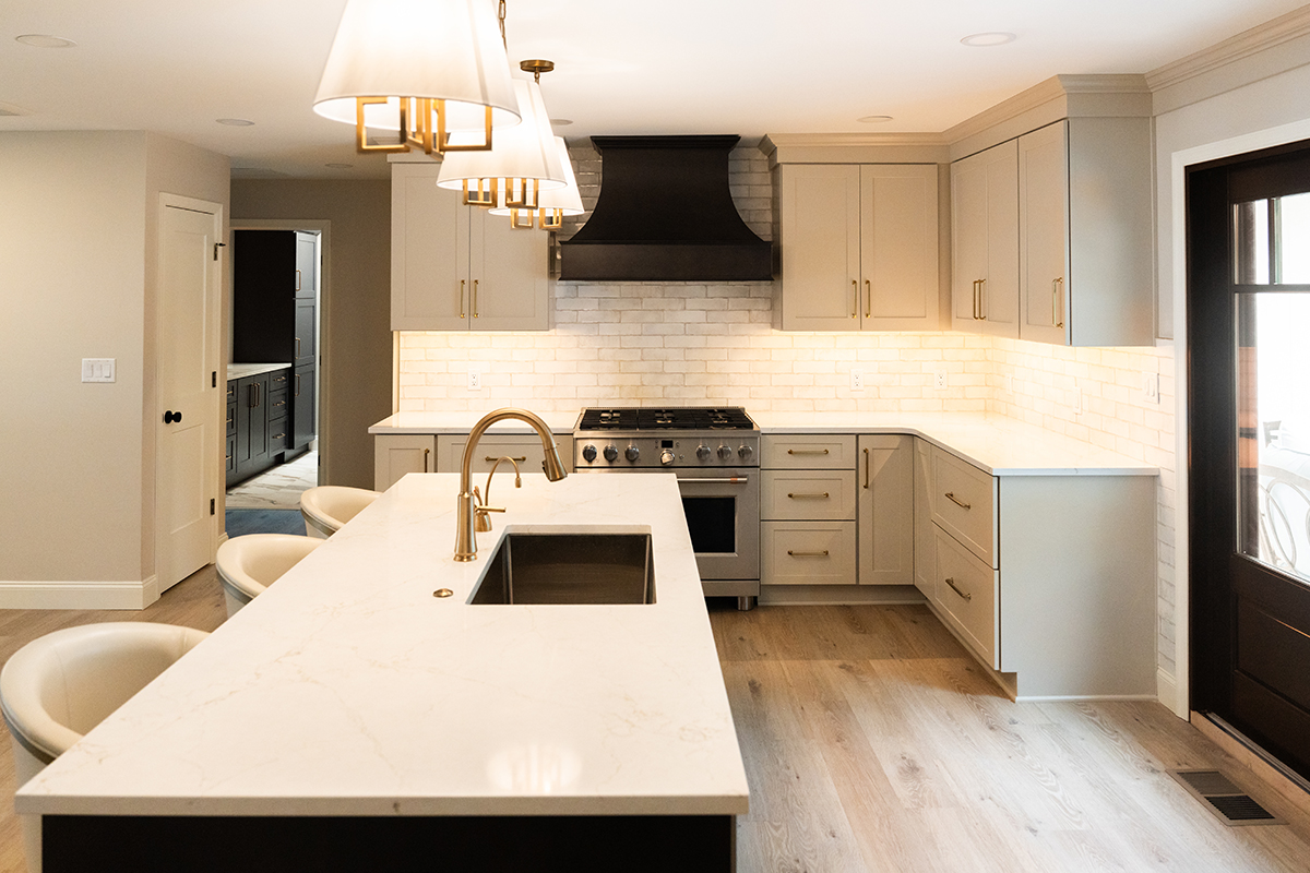 Light Mocha painted perimeter kitchen cabinets and an island with dark stained hood and island.
