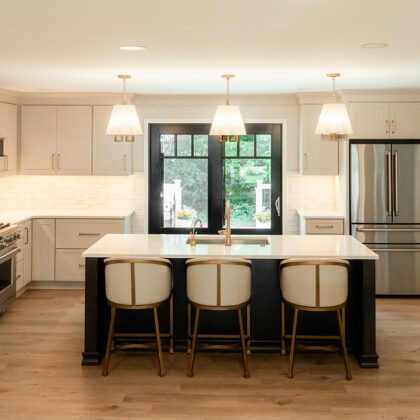 Light Mocha painted perimeter kitchen cabinets and an island with dark stained hood and island.