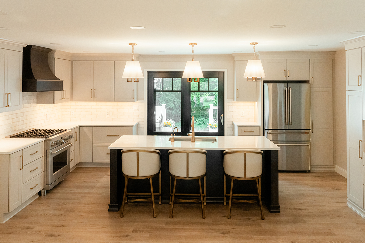 Light Mocha painted perimeter kitchen cabinets and an island with dark stained hood and island.