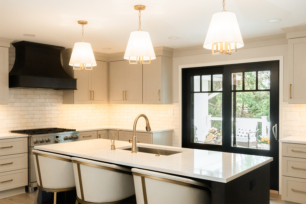 Light Mocha painted perimeter kitchen cabinets and an island with dark stained hood and island.