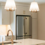 Light Mocha painted perimeter kitchen cabinets with stainless fridge.