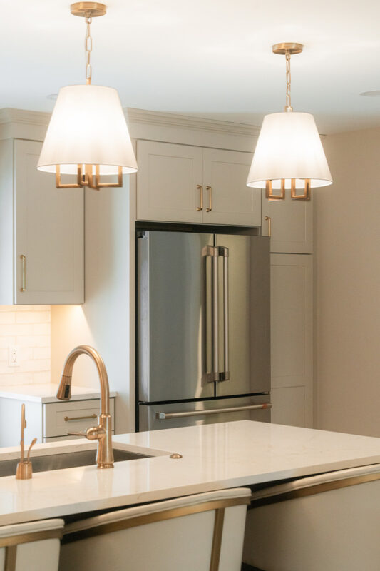 Light Mocha painted perimeter kitchen cabinets with stainless fridge.