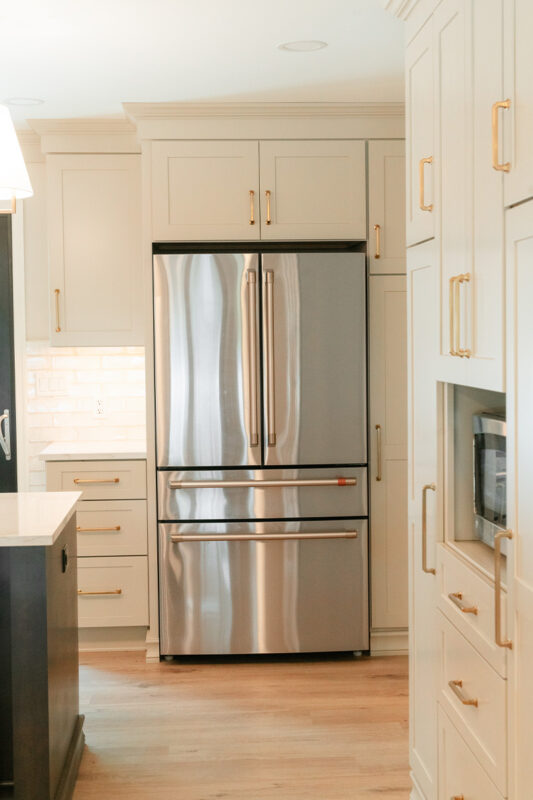 Light Mocha painted perimeter kitchen cabinets with stainless fridge.