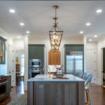 Green and white oak kitchen cabinets and island.