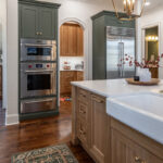 Green and white oak kitchen cabinets and island.