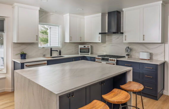 Blue and white kitchen cabinets with white appliances.