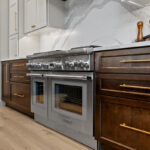 White and dark stained kitchen cabinets with white counter.