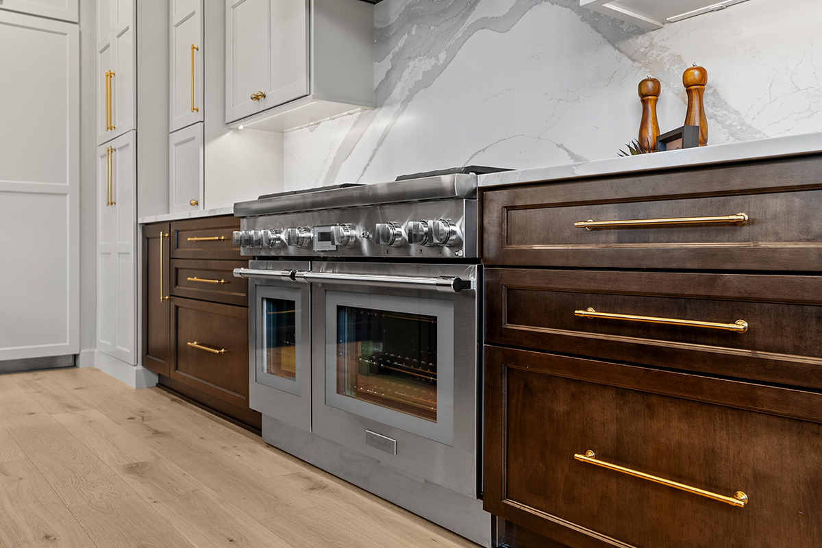 White and dark stained kitchen cabinets with white counter.