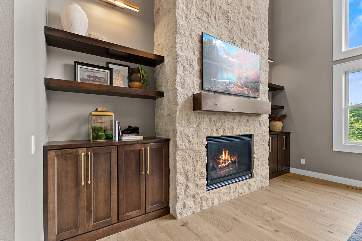 Fireplace with dark stained cabinets on each side.