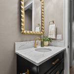 Dark green painted floating vanity with two drawer look in a bathroom.