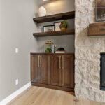 Fireplace with dark stained cabinets on each side.