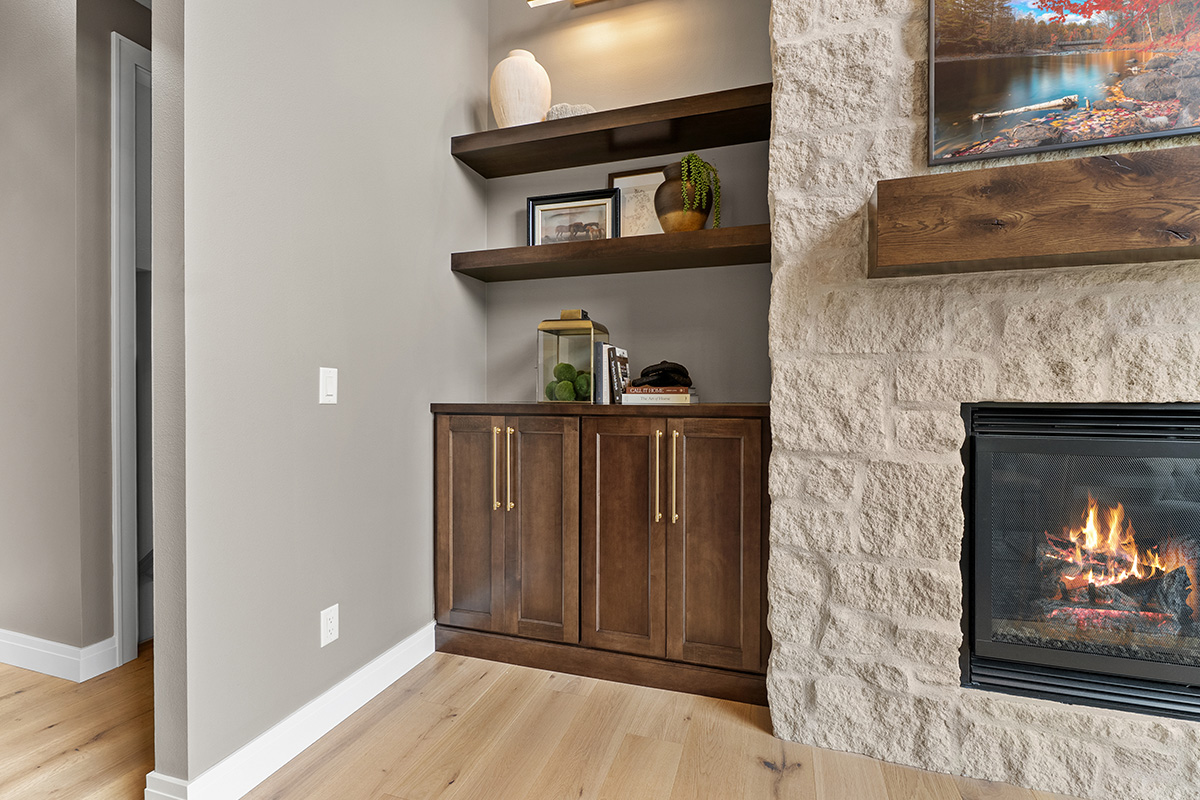 Fireplace with dark stained cabinets on each side.