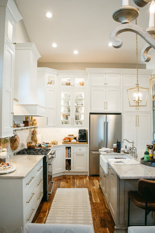 White kitchen perimeter cabinets with brown island.