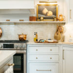 White kitchen cabinets with appetizers on the counter.