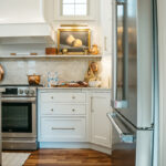 White kitchen perimeter cabinets with brown island.