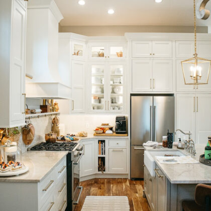 White kitchen perimeter cabinets with brown island.