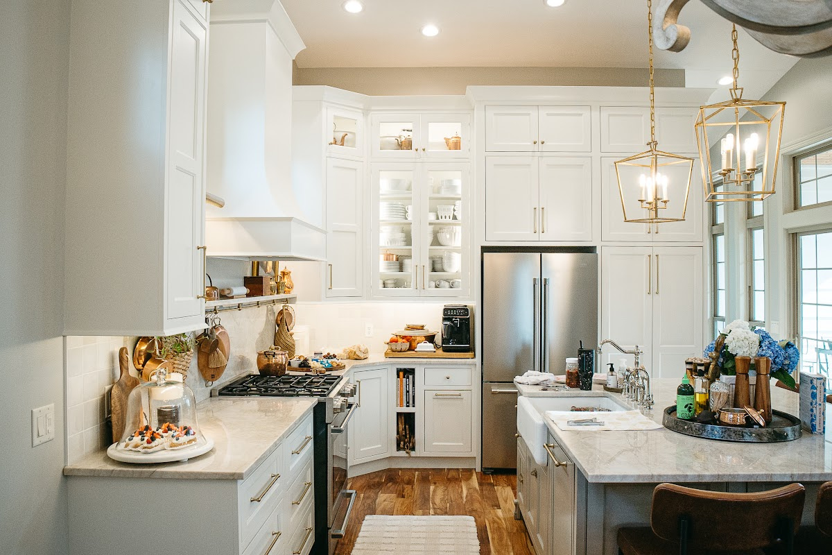 White kitchen perimeter cabinets with brown island.