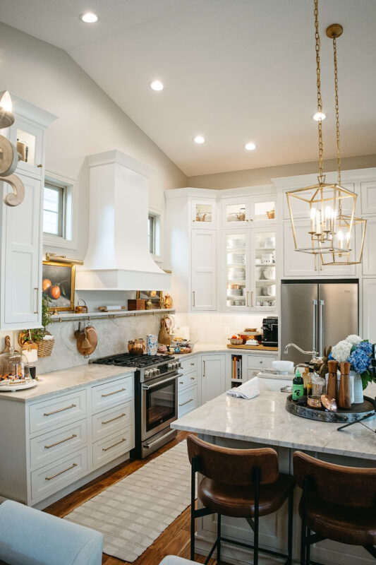 White kitchen perimeter cabinets with brown island.