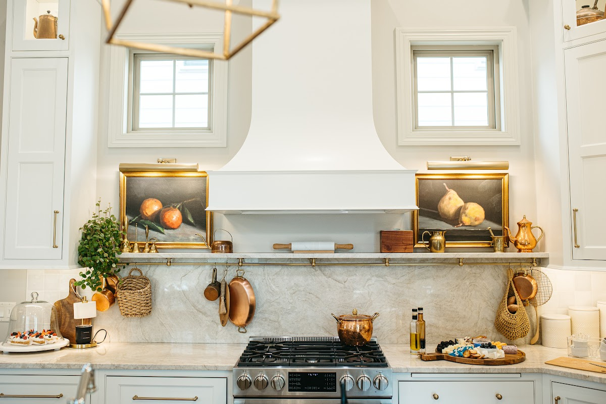 White kitchen cabinets and curved chimney range hood.