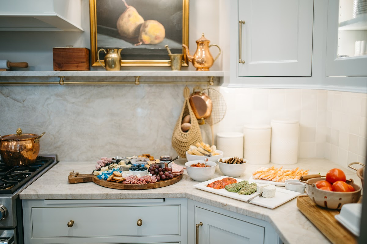 White kitchen cabinets with appetizers on the counter.
