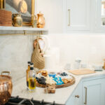 White kitchen cabinets with appetizers on the counter.