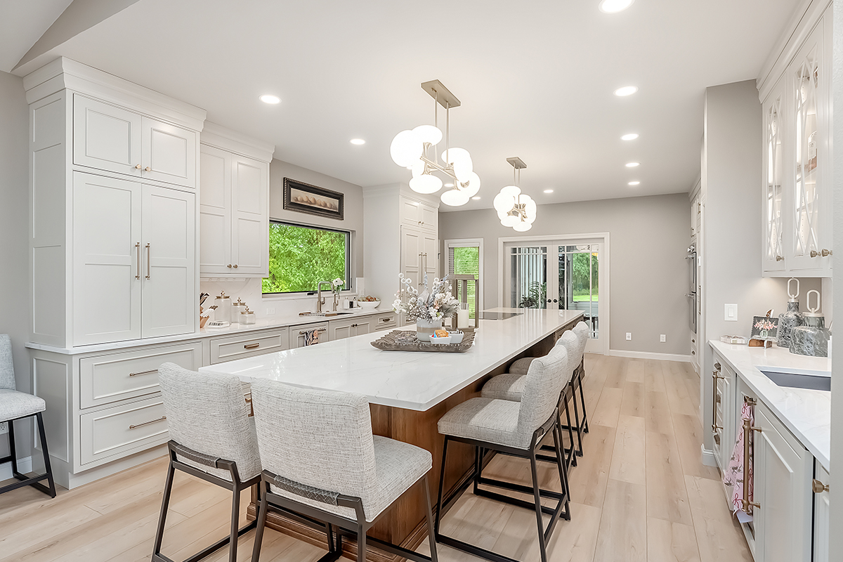 Beige painted kitchen perimeter cabinets with a 16-foot stained quartersawn white oak island wtih seating.