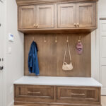 Brown stained mudroom with locker and bench seating