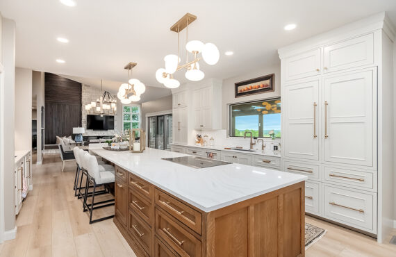 Beige painted kitchen perimeter cabinets with a 16-foot stained quartersawn white oak island wtih seating.