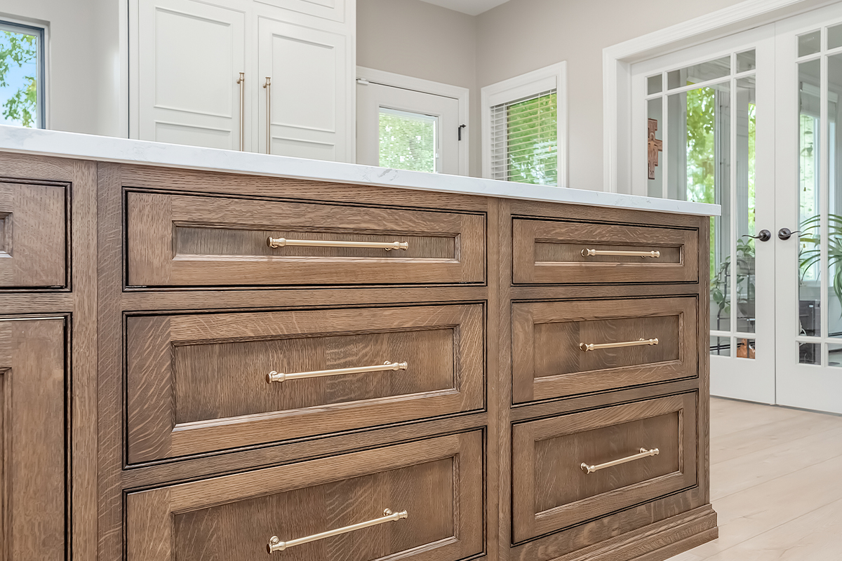 Beige painted kitchen perimeter cabinets with a 16-foot stained quartersawn white oak island wtih seating.