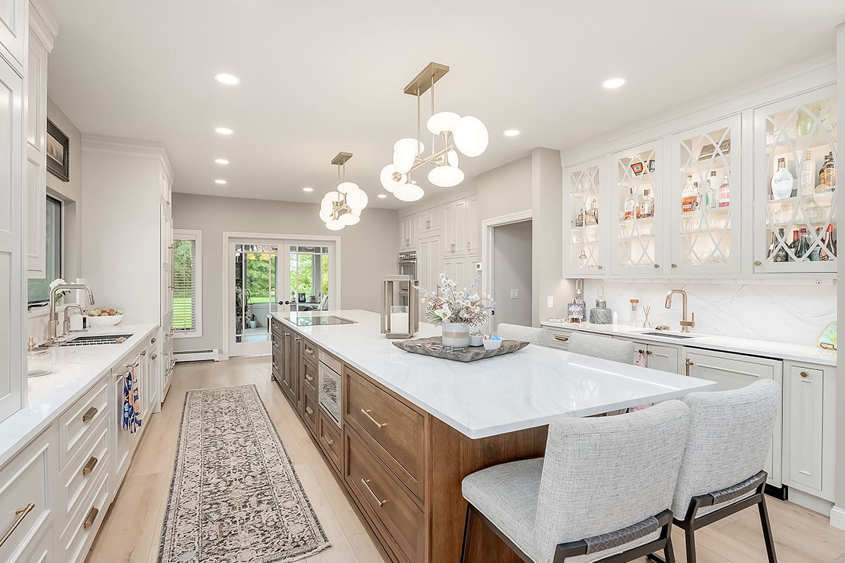 Beige painted kitchen perimeter cabinets with a 16-foot stained quartersawn white oak island wtih seating.
