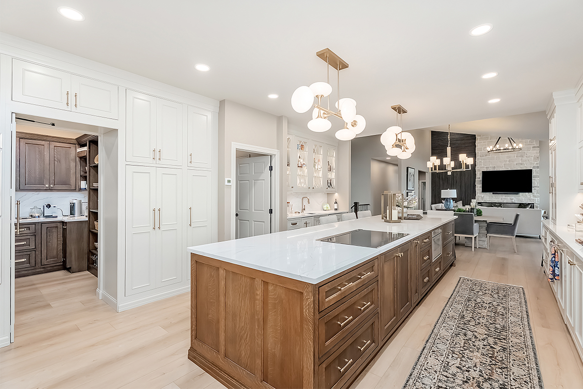Beige painted kitchen perimeter cabinets with a 16-foot stained quartersawn white oak island wtih seating.