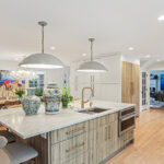 White painted kitchen cabinets with an island in the Ginger textured melamine surface with grains.
